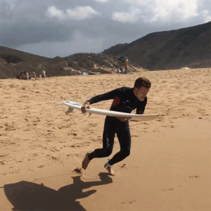 surfer athlete falling on dry sand